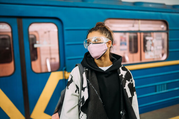 面罩戴着医用防护面罩站在车站的年轻女子2019ncov疾病磨损