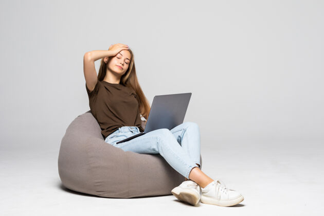 年轻沮丧和沮丧的女人用笔记本电脑工作绝望的工作隔离在白墙上沮丧女孩抑郁笔记本电脑