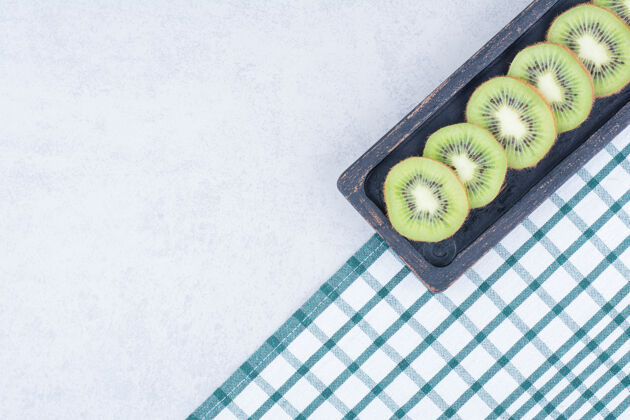 切片在桌布上放一盘黑色的新鲜猕猴桃片盘子素食者食物