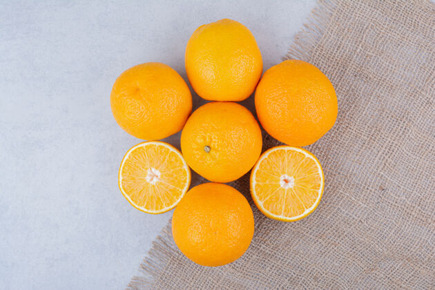 有机新鲜的橙子躺在白色的麻布上素食水果切割
