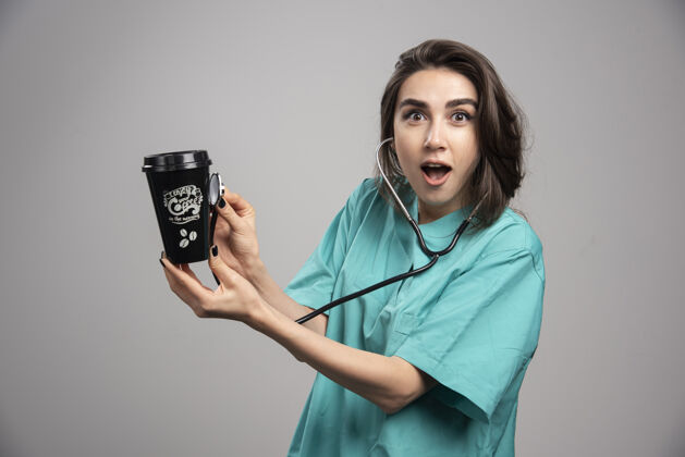 疾病女医生用听诊器检查咖啡杯高质量照片年轻人制服治疗