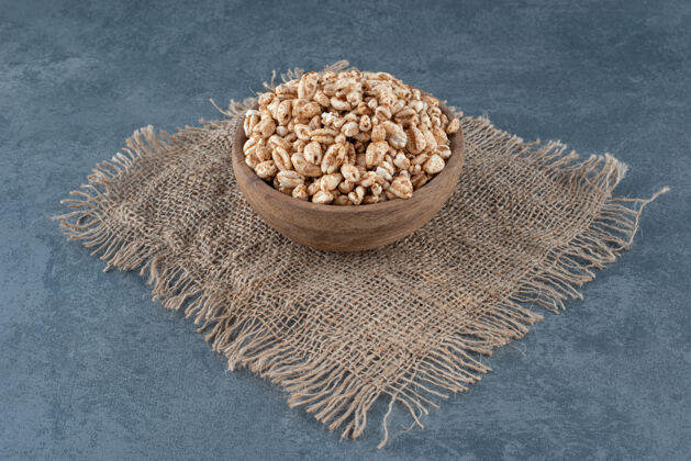 碗在大理石上的一块织物上装满雪花的小木碗饮食零食营养