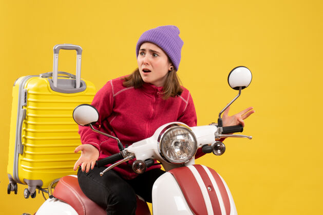 摩托车前视图困惑的年轻女孩穿着红色毛衣的轻便摩托车轻便摩托车传送带车辆