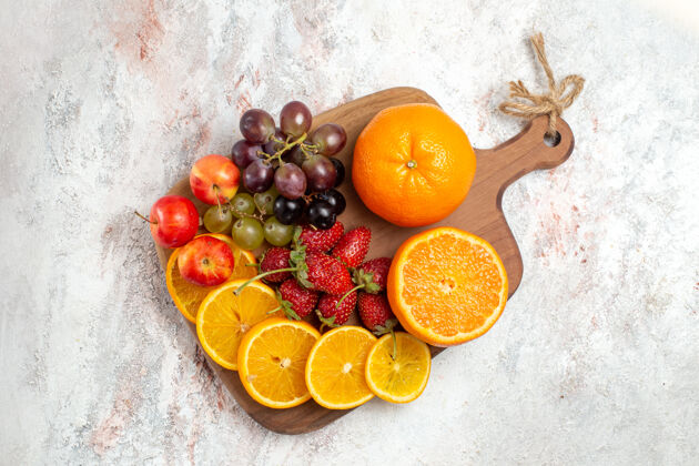 可食水果白色表面上的新鲜水果 橙子 葡萄和草莓的俯视图营养柑橘成熟
