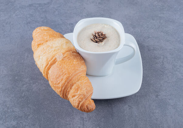 意式早餐一杯卡布奇诺和羊角面包 灰色背景美味羊角面包摩卡咖啡