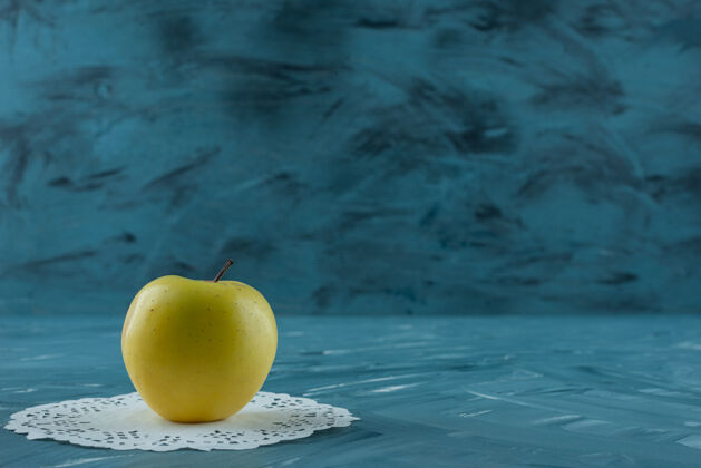 整个一个有机新鲜苹果放在蓝色的表面上健康天然苹果