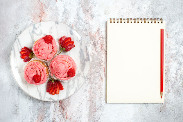 饼干白色表面上有新鲜的红色草莓的粉色草莓蛋糕俯视图庆祝饼干水果