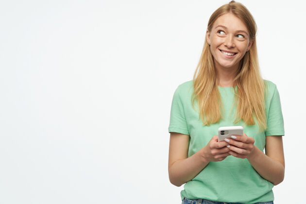 社交网络一个女人微笑着看着旁边的一个复印空间 手里拿着她的手机手臂新闻年轻