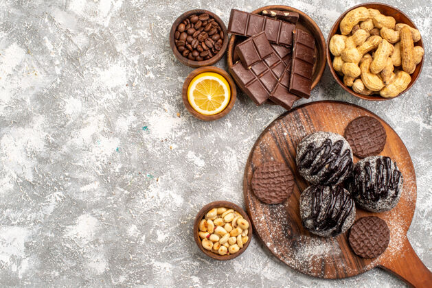 食物白色表面上有饼干和花生的美味巧克力蛋糕俯视图核桃饼干糖