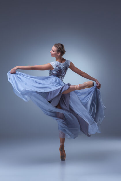 表演美丽的芭蕾舞演员在蓝色背景上穿着蓝色长裙跳舞优雅丝绸服装