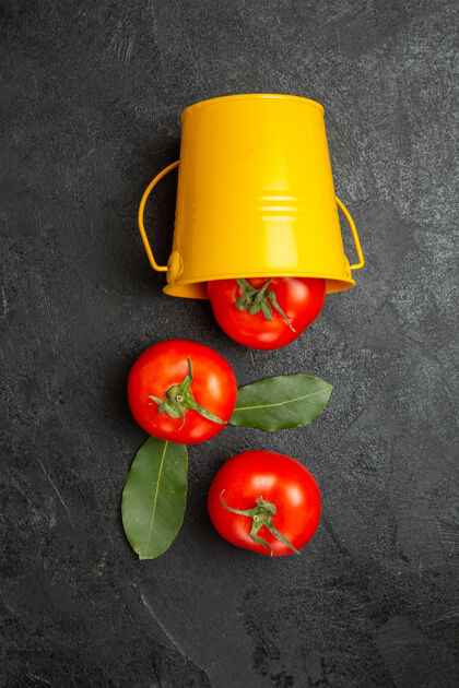 蔬菜顶视图桶与红色西红柿在黑暗的背景成熟素食深色