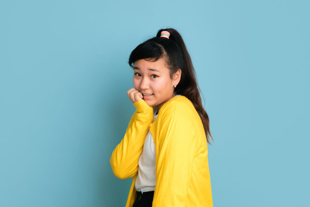 行政在蓝色工作室背景上孤立的亚洲青少年肖像美丽的深褐色女性模特 留着休闲的长发人类情感的概念 面部表情 销售 广告摆可爱的姿势事业人工作