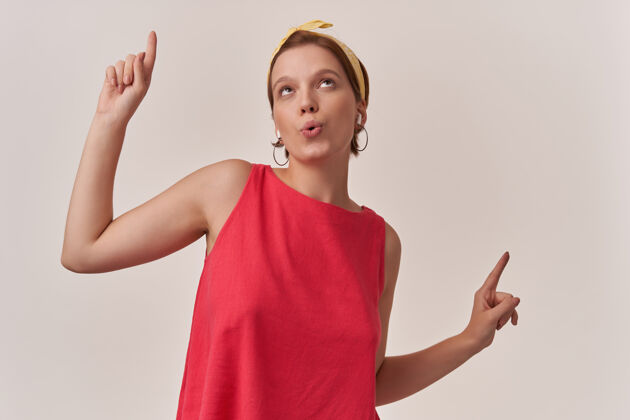 指向自然妆容的女人穿着时髦的夏季流行的红色连衣裙和黄色的大手帕摆姿势黄色头巾姿势
