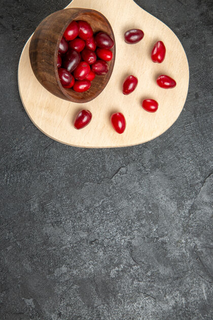 美味深灰色表面上新鲜的红色山茱萸俯视图可食用的水果闪亮浆果
