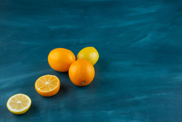 新鲜整个柠檬和切片放在大理石表面上有机明亮柑橘