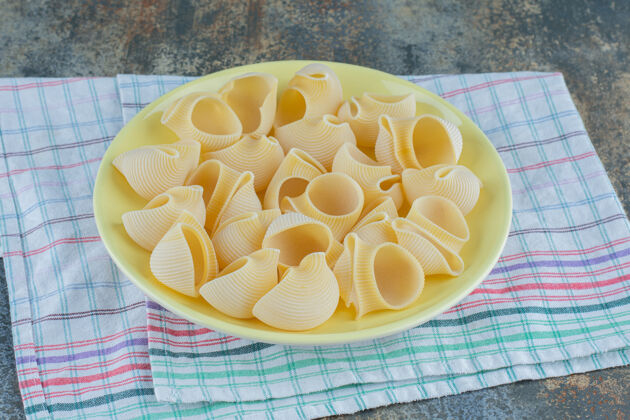 美味把意大利面放在碗里 毛巾放在大理石背景上美味风味未煮