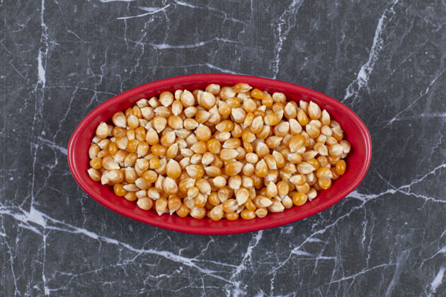 玉米装满玉米种子的红色陶瓷碗俯视图团体膳食蔬菜