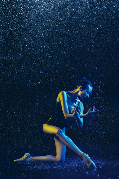 下降年轻的女芭蕾舞演员在水滴和浪花下表演白种人模特在霓虹灯下跳舞迷人的女人芭蕾舞和当代舞蹈概念创意艺术照片明亮现代人