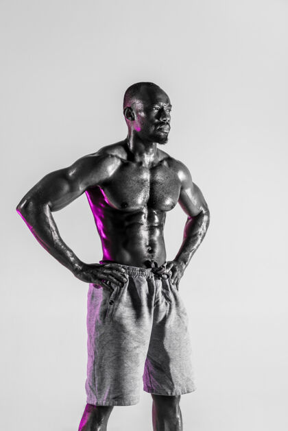 运动努力总是有回报的年轻的非洲裔美国人在灰色背景下进行健美训练穿着运动服的肌肉发达的单身男模运动的概念 健美 健康的生活方式健身握持肌肉