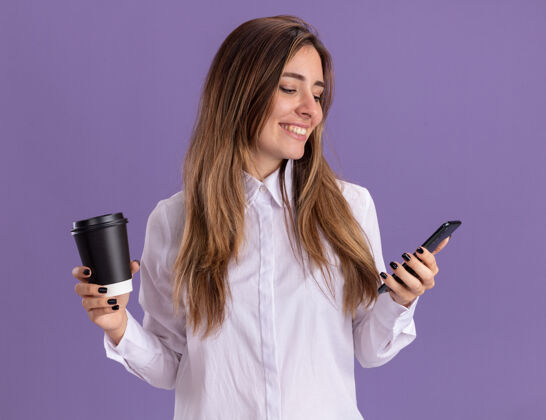 微笑年轻漂亮的白人女孩微笑着拿着纸杯 看着紫色的手机杯子紫色漂亮