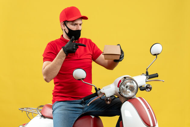 惊喜上图是一个穿着红色上衣 戴着帽子手套 戴着医用面罩的送货员坐在滑板车上显示秩序坐摩托车男人