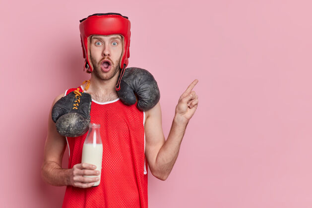 健身震惊活跃的男拳击手穿着运动服 脖子上戴着拳击手套 拿着一瓶牛奶作为钙的来源 点开复制空间手套决心斗士
