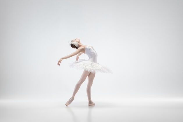 灵活优雅的经典芭蕾舞演员在白色的工作室背景下跳舞穿着柔软衣服的女人像一只白天鹅优雅 艺术家 运动 动作和运动的概念看起来没有重量优雅愉悦情侣