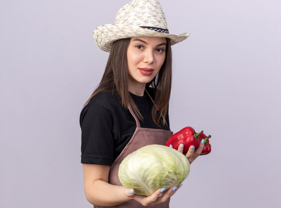 花园自信漂亮的白人女园丁戴着园艺帽 手里拿着红辣椒和白卷心菜帽子自信园艺