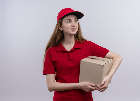 复制带着微笑的年轻送货员 穿着红色制服 拿着盒子 看着右边的空白处 空白处有复印件微笑右边拿着