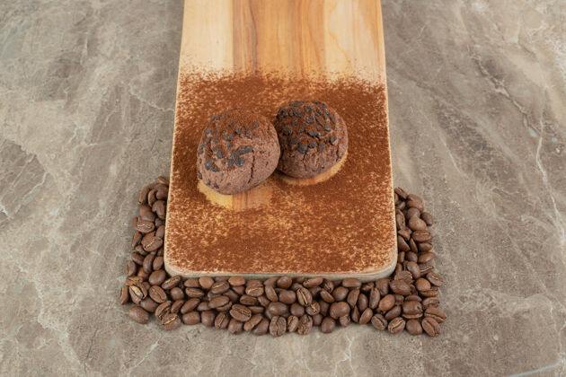 食品两块巧克力饼干放在木盘上 上面放着咖啡豆配料甜点咖啡豆