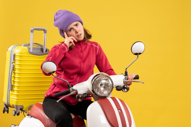 运动前视图困惑的年轻女孩骑着轻便摩托车看前面成人肖像人