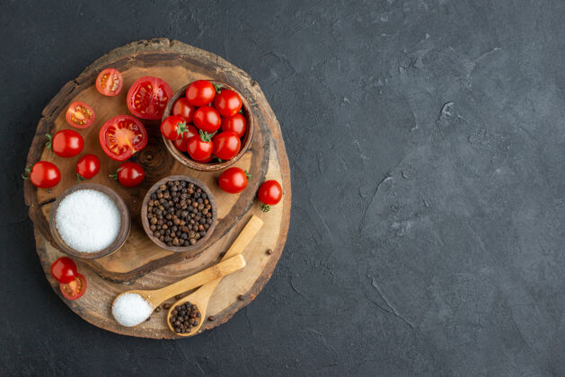 食品新鲜西红柿和香料在木板上的黑色表面右侧俯视图香料甜点板