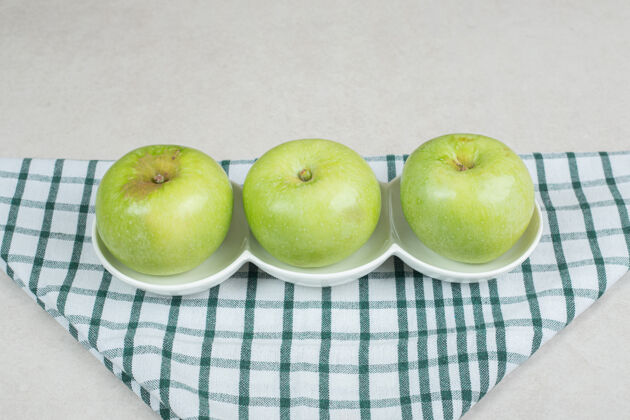 有机整个青苹果放在白板上 还有条纹桌布水果食品营养