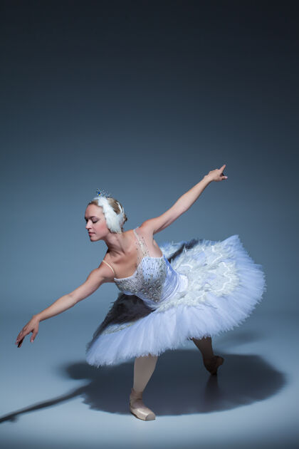 表演芭蕾舞演员在蓝色背景下扮演白天鹅的肖像戏剧天鹅湖经典