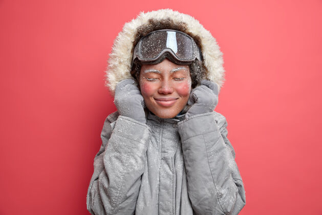 外套积极的冬季休息和户外运动的概念满意的女人闭上眼睛 微笑愉快地享受休闲时间最喜欢的爱好去滑雪在山区低温服装女人休息霜冻