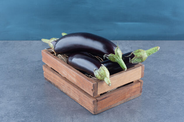 自然成熟的新鲜茄子放在木箱里成熟食品紫色