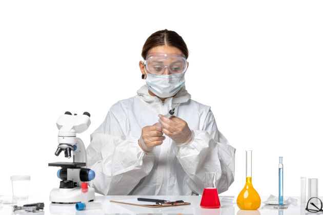 实验室外套前视图穿着防护服 戴着口罩的女医生正在注射浅白色背景的病毒药物covid大流行正面健康防护