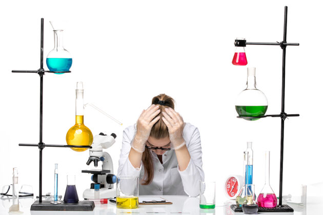 视图前视图穿着医疗服的女化学家坐在白色背景上 带着溶液 感到疲倦套装感觉女化学家