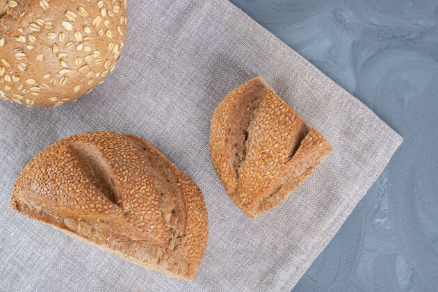 切片在大理石桌上的毛巾上涂上芝麻涂层的面包片面包好吃的好吃的