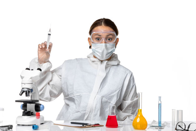 男性正面图：穿着防护服 戴着口罩的女医生正在注射白桌病毒药物 以防病毒大流行病毒注射男人