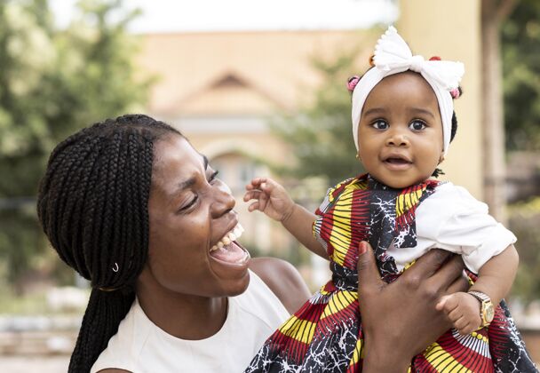 成人非洲妈妈抱着小女孩父母水平种族