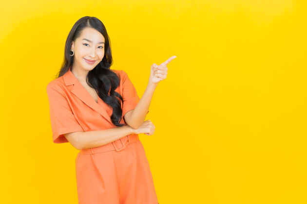 模特肖像美丽的亚洲年轻女子微笑着行动黄色时尚肖像时尚
