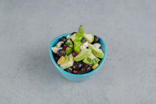晚餐蓝色杯子里的沙拉 混合切碎的蔬菜和水果传统灰色混凝土