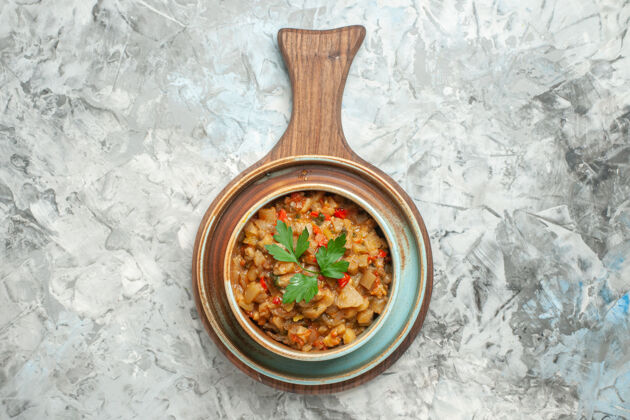木勺灰色表面上碗中烤茄子沙拉的俯视图蔬菜晚餐烤肉
