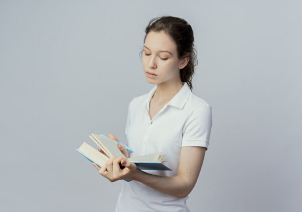 专注专注的年轻漂亮的女学生拿着另一只手拿着钢笔看书隔离在白色背景和复印空间手持阅读白色