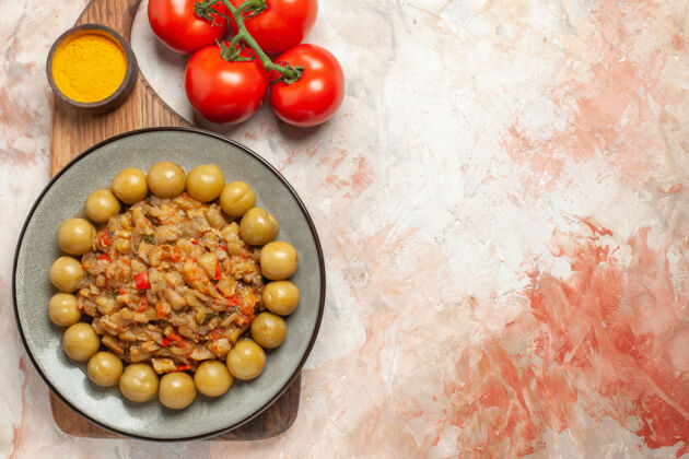 茄子沙拉烤茄子沙拉的顶视图在盘子上切菜板西红柿在裸体表面水果午餐晚餐