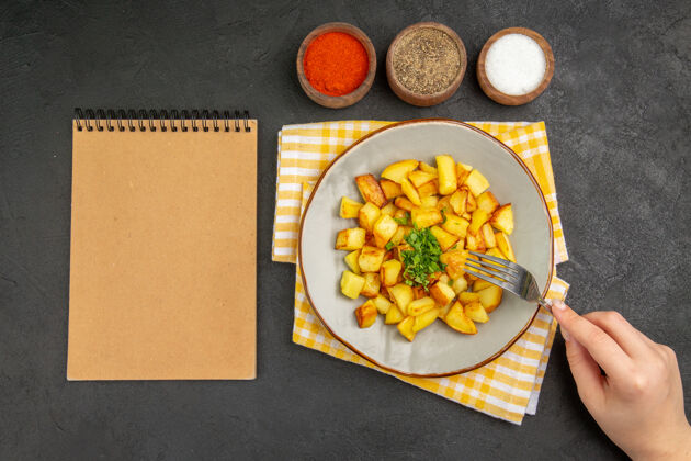 水果美味的炸土豆在黑暗的表面与调味品盘子内俯视图午餐里面饮食