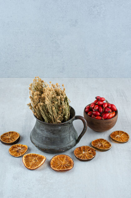 成熟的一碗玫瑰果 干橘子和石头表面的芸香美味水果切片