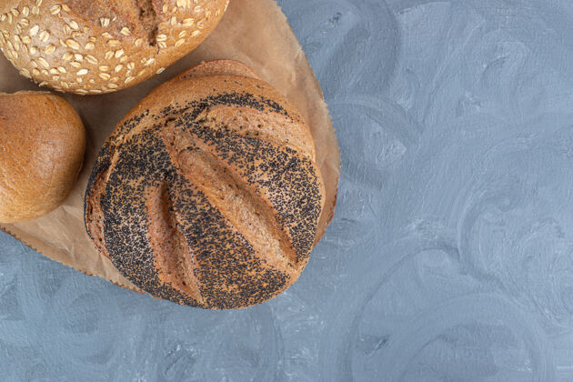 美味不同类型的面包捆在大理石桌上的木板上品种芝麻可口