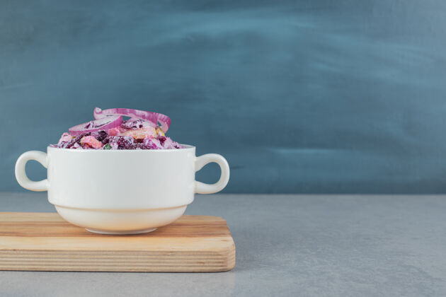 盘子切碎的紫洋葱和卷心菜沙拉放在陶瓷杯里传统灰色美味